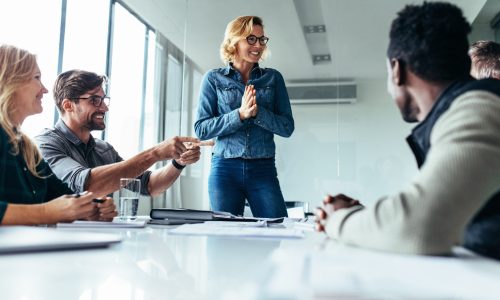 Young,Happy,Woman,Presenting,Her,Idea,To,Colleagues,In,Meeting.